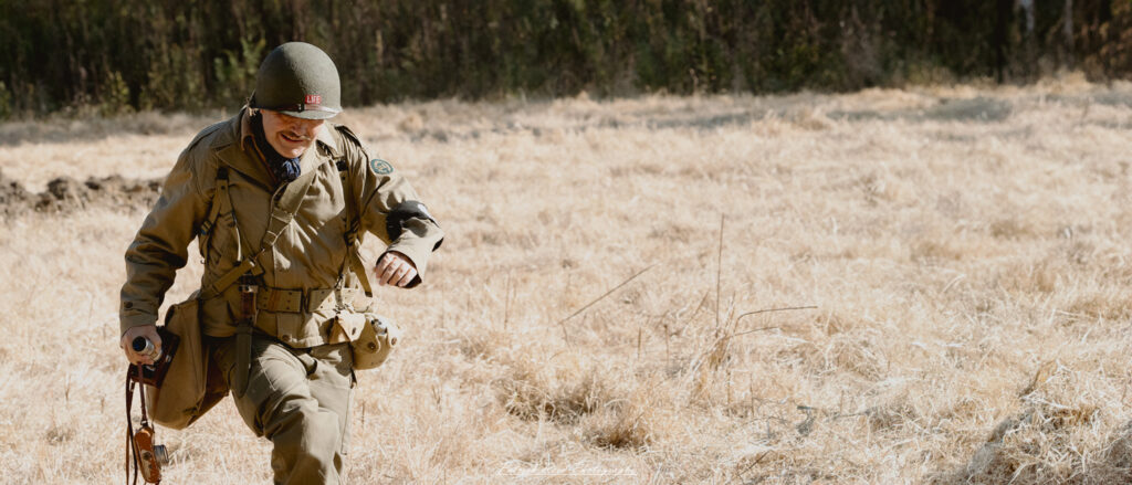 "WW2 combat correspondent capturing the realities of war. The scene features a journalist in a military uniform, equipped with a camera and notepad, documenting the action on the front lines. Surrounding him are soldiers engaged in combat, with smoke and chaos in the background. The correspondent is focused, highlighting the dual role of documenting history while being in the midst of battle. This image emphasizes the bravery and dedication of those who reported on the war, providing a unique perspective on the experiences of soldiers during World War II."